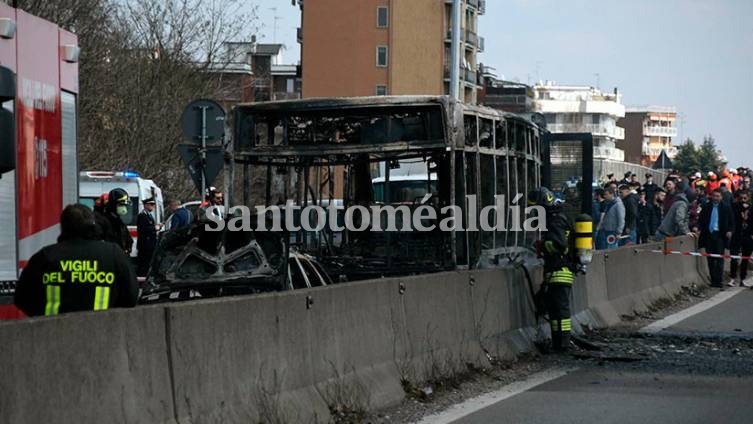 Bomberos junto a los restos de un autobús en San Donato Milanese, Italia, el 20 de marzo de 2019. (Daniele Bennati / AP)