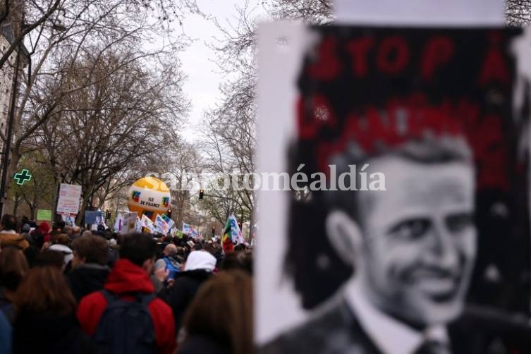 Manifestantes sostienen un dibujo que representa un retrato del presidente Emmanuel Macron durante una marcha. (Foto: NA)